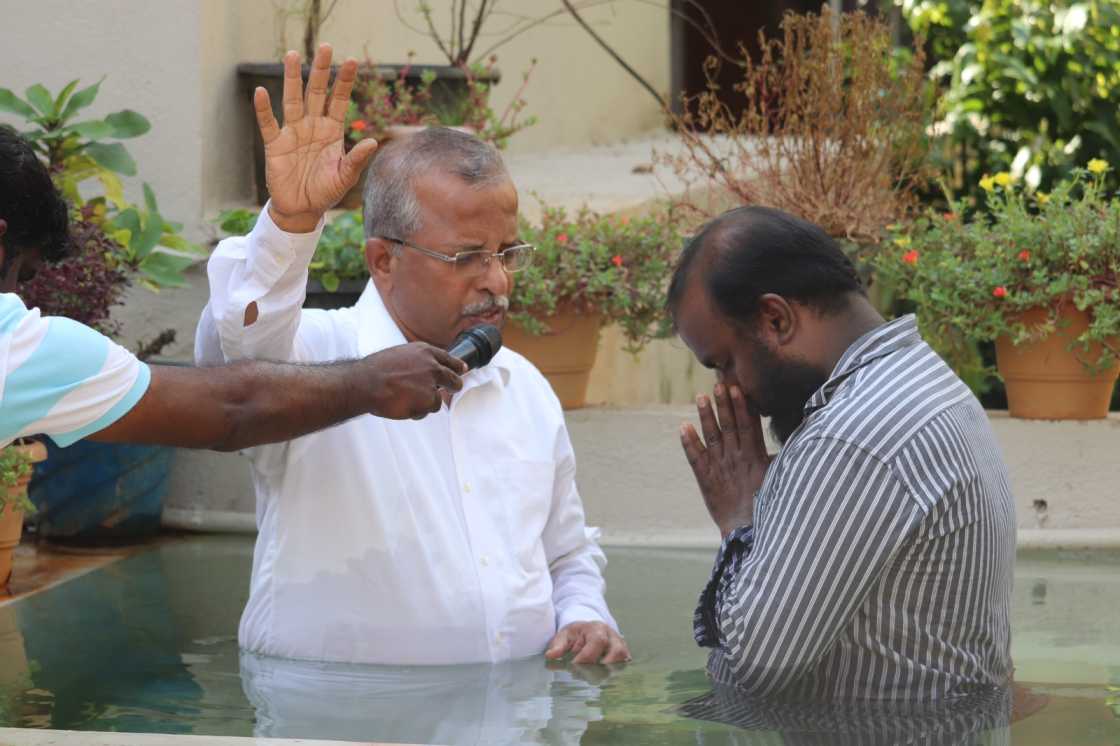 water baptism given by pastor to church believer